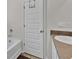 This bathroom features a white door, bathtub, wall tiling, and vanity at 1054 Mackets Ct, Atlanta, GA 30354