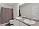 This bathroom includes double sinks, shower with curtain, and a large mirror at 1054 Mackets Ct, Atlanta, GA 30354