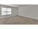 This empty, carpeted bedroom has a window for natural light and a neutral paint color at 1054 Mackets Ct, Atlanta, GA 30354
