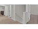 Upstairs hallway with carpet flooring, a white handrail, and doors at 1054 Mackets Ct, Atlanta, GA 30354