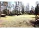 Expansive backyard featuring a large grassy area, mature trees, shed, and partial fencing at 2110 E Cherokee Dr, Woodstock, GA 30188