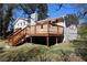 Exterior view of updated home, featuring wood deck and a large backyard at 2110 E Cherokee Dr, Woodstock, GA 30188
