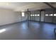 Spacious basement with painted floor, white walls, and large garage doors providing ample natural light at 2110 E Cherokee Dr, Woodstock, GA 30188