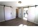 Bright bedroom with hardwood floors, sliding barn doors and fresh neutral paint at 2110 E Cherokee Dr, Woodstock, GA 30188