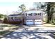 Charming home features a brick facade, white trim, a dark roof, and an attached two-car garage at 2110 E Cherokee Dr, Woodstock, GA 30188