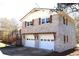 Charming home features a brick facade, white trim, a dark roof, and an attached two-car garage at 2110 E Cherokee Dr, Woodstock, GA 30188