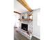 Stylish whitewashed brick fireplace featuring a rustic wood mantle and decorative accents at 2110 E Cherokee Dr, Woodstock, GA 30188