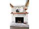Close-up of whitewashed brick fireplace with mantle and decorative items at 2110 E Cherokee Dr, Woodstock, GA 30188