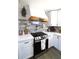 Updated kitchen featuring stainless steel stove, white cabinets, and stylish backsplash at 2110 E Cherokee Dr, Woodstock, GA 30188