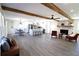 The open-concept living space features a brick fireplace, beamed ceilings, and luxury vinyl flooring at 2110 E Cherokee Dr, Woodstock, GA 30188