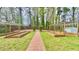 Backyard featuring raised garden beds, a brick path, and lush greenery at 4083 Rivermeade Sw Dr, Lilburn, GA 30047