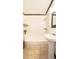 Clean bathroom featuring a tub and shower with modern fixtures and pedestal sink at 4083 Rivermeade Sw Dr, Lilburn, GA 30047