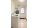 Bright laundry room with tiled floor, large capacity washer, and utility tub at 4083 Rivermeade Sw Dr, Lilburn, GA 30047