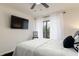 Serene bedroom featuring a queen bed, a wall-mounted TV, and sheer white curtains at 795 Hammond Dr # 407, Sandy Springs, GA 30328