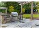 Outdoor grill with stone base, stainless steel grill, food prep area and picnic table in community area at 795 Hammond Dr # 407, Sandy Springs, GA 30328