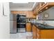 Well-lit kitchen featuring stainless appliances, wooden cabinets, granite counters and tile flooring at 795 Hammond Dr # 407, Sandy Springs, GA 30328