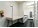 Community laundry room with multiple modern washing machines, drying racks, folding table, and black floors at 795 Hammond Dr # 407, Sandy Springs, GA 30328