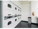 Bright laundry room with multiple sets of white, front-loading washing machines and dryers at 795 Hammond Dr # 407, Sandy Springs, GA 30328