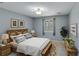 Cozy bedroom features beautiful wood furniture, calm light-blue walls, and natural lighting at 2715 Brook Valley Dr, Cumming, GA 30041