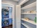 Laundry room featuring modern washer and dryer units with nearby pantry shelving and cabinets at 2715 Brook Valley Dr, Cumming, GA 30041
