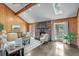 Spacious living room with wood paneled walls, stone fireplace, and large windows creating a warm and inviting atmosphere at 2715 Brook Valley Dr, Cumming, GA 30041