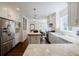 Well-lit kitchen with stainless steel appliances, white cabinetry, marble countertops, and a central island for a modern, functional design at 3790 Narmore Ne Dr, Atlanta, GA 30319