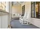Relaxing porch setting with a swing, white rocking chairs, and classic columns with views of the landscaped yard at 3790 Narmore Ne Dr, Atlanta, GA 30319