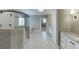 Bright bathroom featuring a frameless shower, soaking tub, dual vanities, granite counters, and gray herringbone flooring at 4296 Alba Ln, Buford, GA 30519
