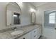 A stylish bathroom features double sinks, granite countertops, white cabinets, and modern lighting at 4296 Alba Ln, Buford, GA 30519