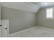 A simple room with neutral walls and carpet, featuring a window and a small door at 4296 Alba Ln, Buford, GA 30519