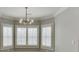 Bedroom with modern light fixture, windows with plantation shutters, and neutral walls at 4296 Alba Ln, Buford, GA 30519