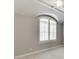This sunlit bedroom boasts a high ceiling, ceiling fan and arched window with white shutters at 4296 Alba Ln, Buford, GA 30519