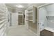A bright walk-in closet featuring plenty of built-in shelving for storage and organization at 4296 Alba Ln, Buford, GA 30519