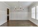 Elegant dining room featuring hardwood floors, wainscoting, and a stylish chandelier at 4296 Alba Ln, Buford, GA 30519