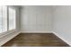 Bright, empty room with hardwood floors, a large window, and decorative wall paneling at 4296 Alba Ln, Buford, GA 30519
