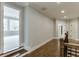 Hallway features hardwood floors, staircase, and entry into a bedroom with lots of light at 4296 Alba Ln, Buford, GA 30519