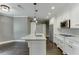 This kitchen boasts white cabinets, granite countertops, stainless steel appliances, and pendant lighting over the island at 4296 Alba Ln, Buford, GA 30519