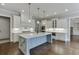 A bright kitchen features white cabinets, stainless steel appliances, and a large center island with stone countertops at 4296 Alba Ln, Buford, GA 30519