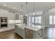A modern kitchen with stainless steel appliances, light gray cabinets, and a large island with a farmhouse sink at 4296 Alba Ln, Buford, GA 30519