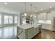 An open kitchen features stainless steel appliances, light gray cabinets, and a large island with an apron-front sink at 4296 Alba Ln, Buford, GA 30519
