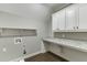 A clean laundry room featuring built-in cabinets and a countertop for folding clothes at 4296 Alba Ln, Buford, GA 30519