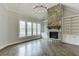 A bright living room showcases a stone fireplace, built-in bookshelves, and multiple windows with natural light at 4296 Alba Ln, Buford, GA 30519
