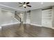 Open-concept living room features hardwood floors, a staircase, built-in shelving, and a ceiling fan at 4296 Alba Ln, Buford, GA 30519