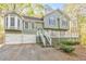 Charming exterior of home featuring a two-car garage and a spacious front porch with white railings at 1013 Harbor Ct, Woodstock, GA 30189