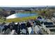 Aerial view of modern homes near a lake, green fields, and businesses, close to a serene landscape at 155 Breakspear Ln, Fayetteville, GA 30214