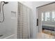 Modern bathroom featuring a tiled shower/bath and a bedroom in the background at 155 Breakspear Ln, Fayetteville, GA 30214