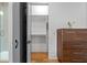 Bright bedroom features walk-in closet and a wooden dresser with fresh flowers at 155 Breakspear Ln, Fayetteville, GA 30214
