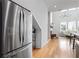 Modern kitchen featuring stainless steel refrigerator, hardwood floors, and an open layout to the living area with natural light at 155 Breakspear Ln, Fayetteville, GA 30214