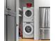 Convenient laundry closet with stacked washer/dryer and a modern stainless refrigerator at 155 Breakspear Ln, Fayetteville, GA 30214