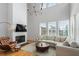Bright living room featuring a cozy seating area, fireplace, TV, and large windows at 155 Breakspear Ln, Fayetteville, GA 30214